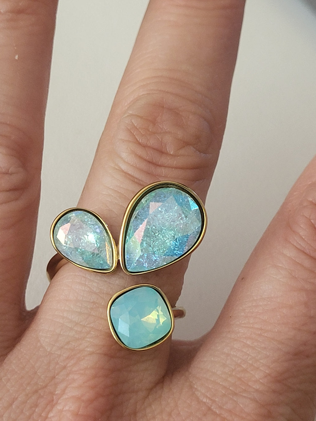 Bague dorée ajustable ornée de 3 pierres irisées bleu
