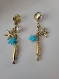 Boucles d’oreilles dorées pendantes poisson et étoile de mer bleu