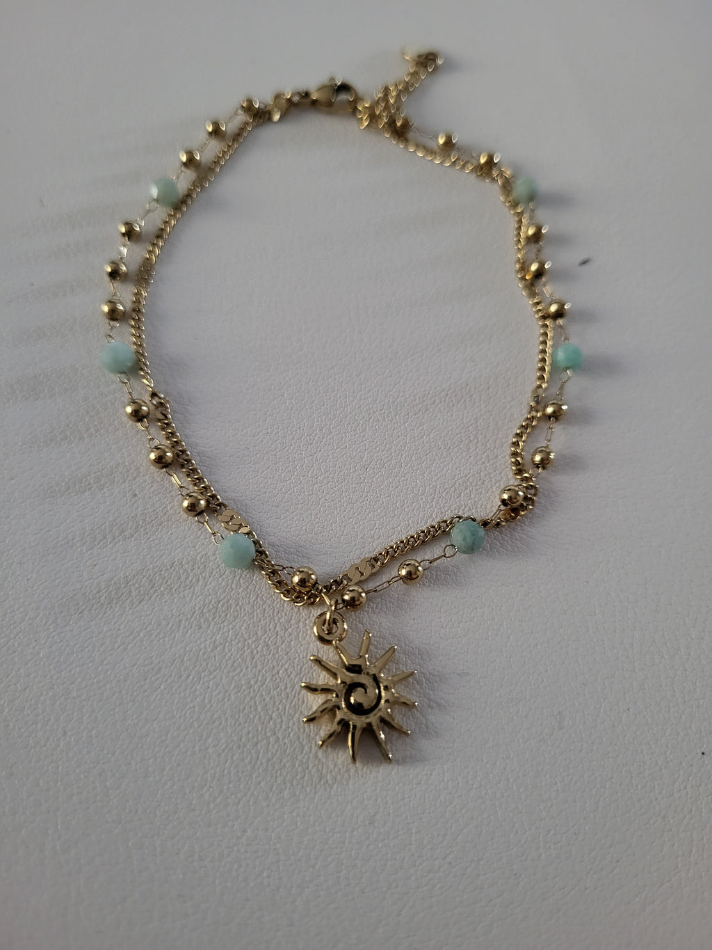 Chaîne de cheville dorée double rang soleil et perles bleu