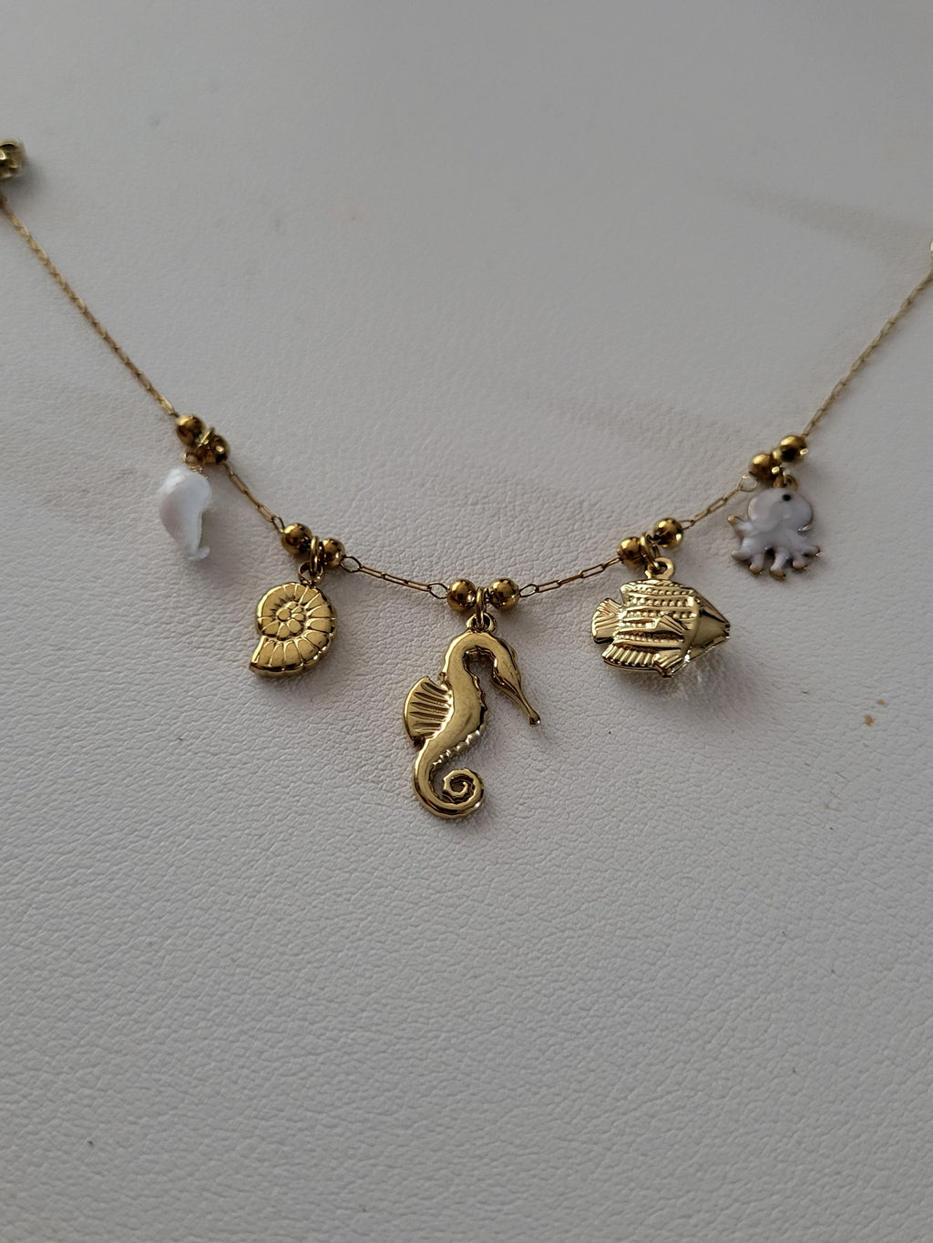 Bracelet à charms hippocampe et poulpe nacré doré