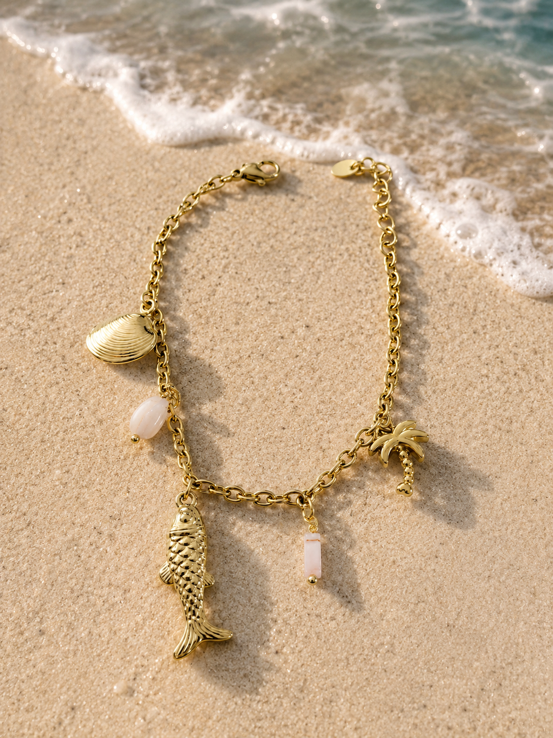 Bracciale dorato con charms marini, palma e pietre rosa