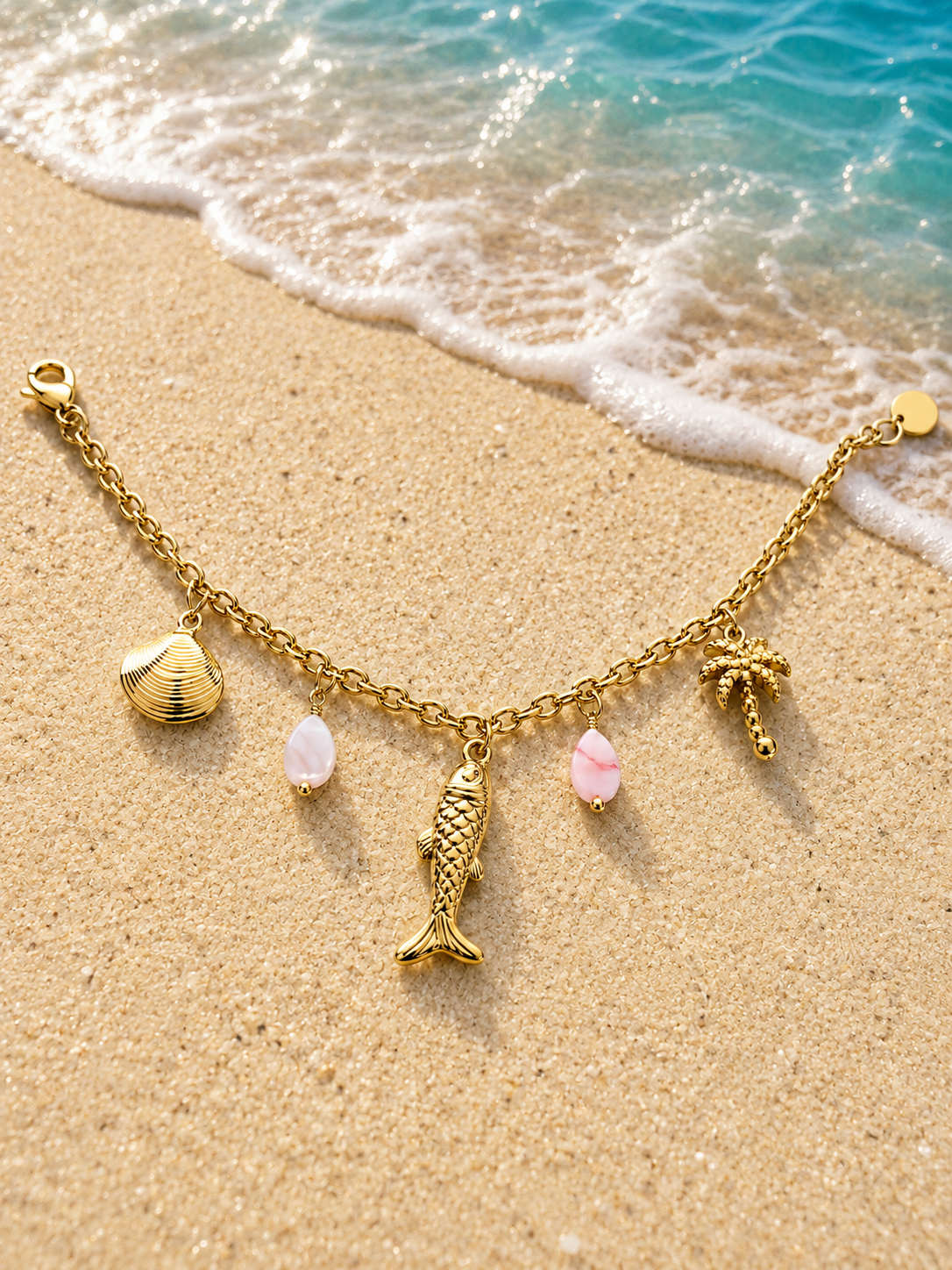 Bracciale dorato con charms marini, palma e pietre rosa