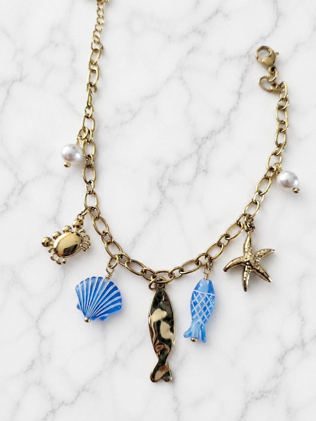 Braccialetto dorato ciondoli marini blu e granchio in strass