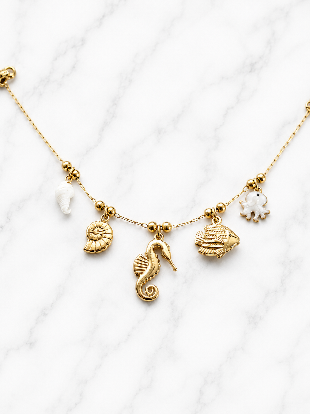 Bracciale con charms ippocampo e polpo perlato dorato